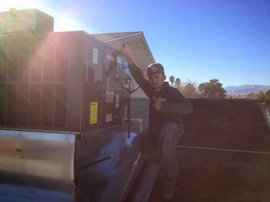 HVAC technician performing HVAC Inspection on a rooftop unit in Indio